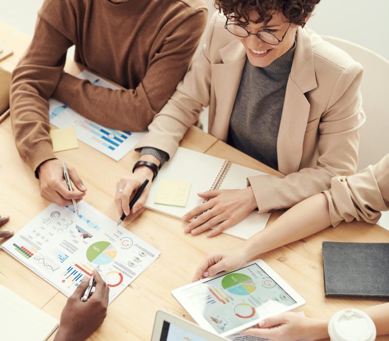 pexels-photo-3184287-3184287 A diverse team of professionals collaborating over charts and graphs during a business meeting.